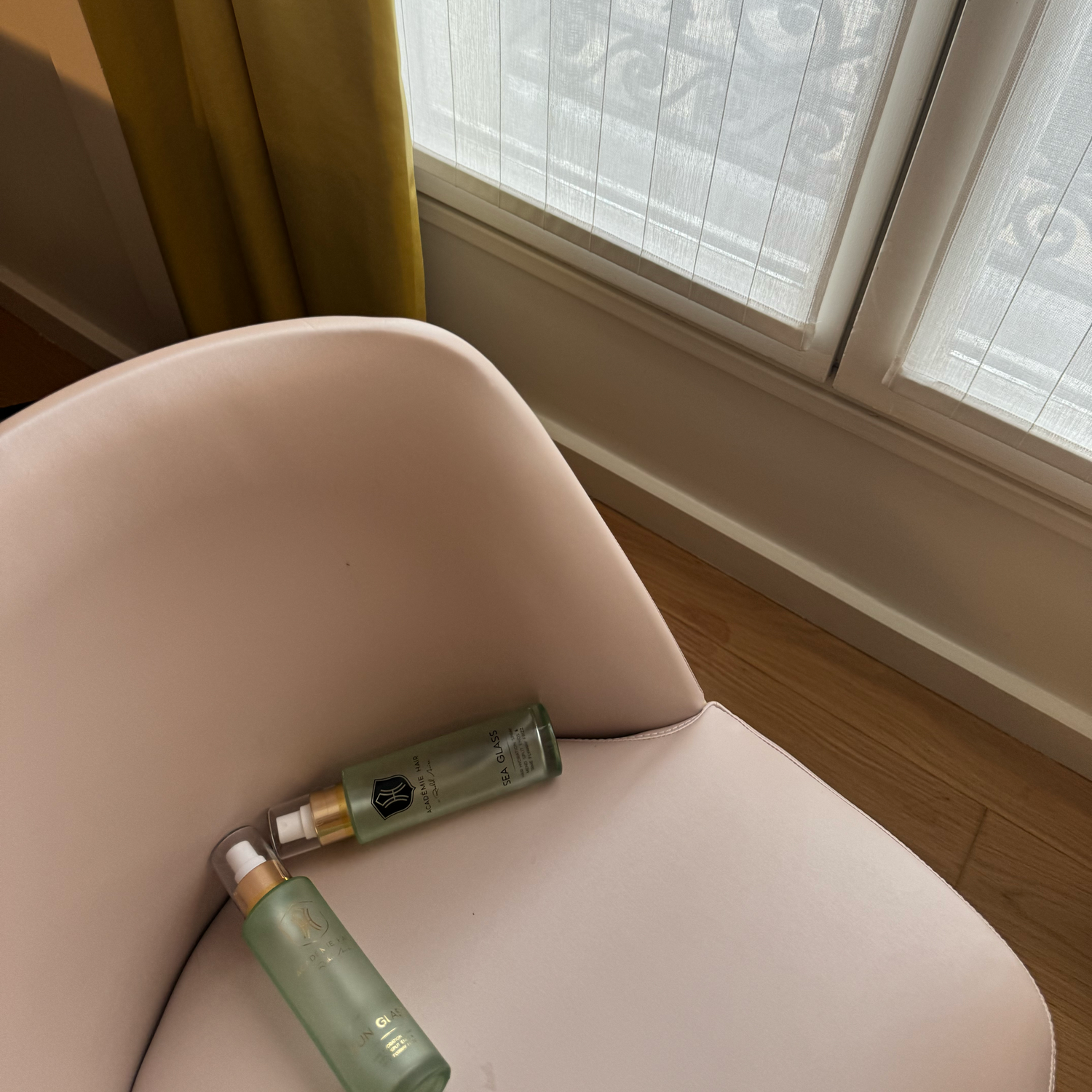 Sea Glass bottles on a beige chair with a window in the background